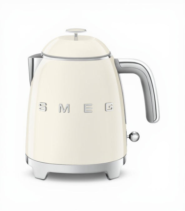 Cream-colored kettle with silver handle and 'SMEG' branding on a white background